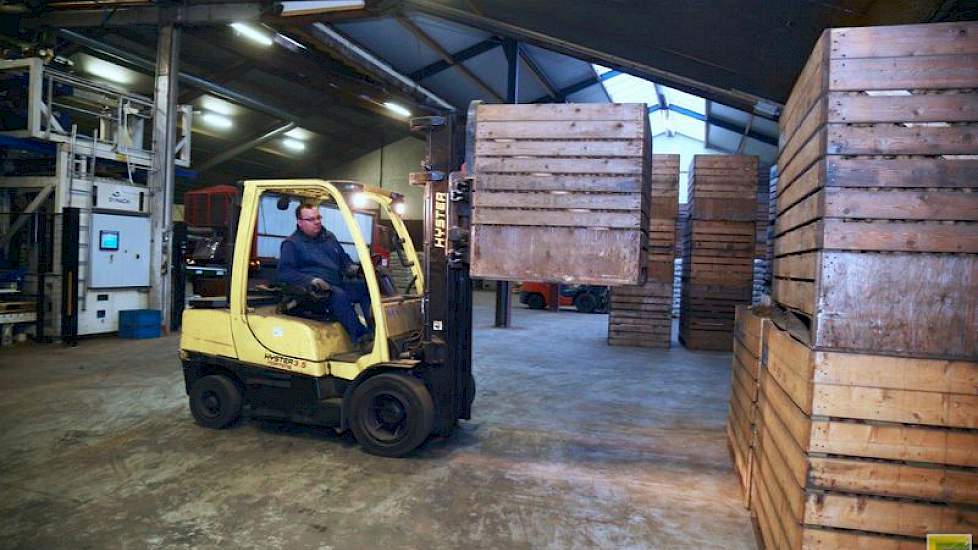 Nieuwe kuubskisten worden aangevoerd. Links op de achtergrond de palletiseermachine van Symach.