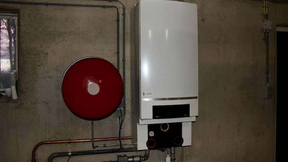 In het portaal hangt een boiler met expansievat voor de vloerverwarming.