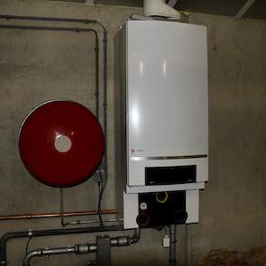 In het portaal hangt een boiler met expansievat voor de vloerverwarming.