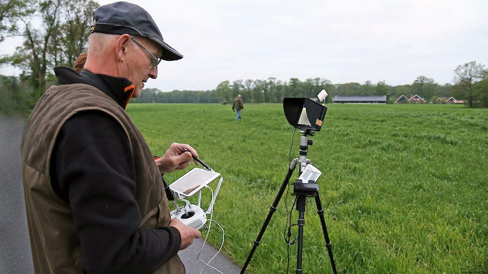 Willy Kruisselbrink bestuurt de drone met behulp van een tablet en een klein scherm op een standaard.