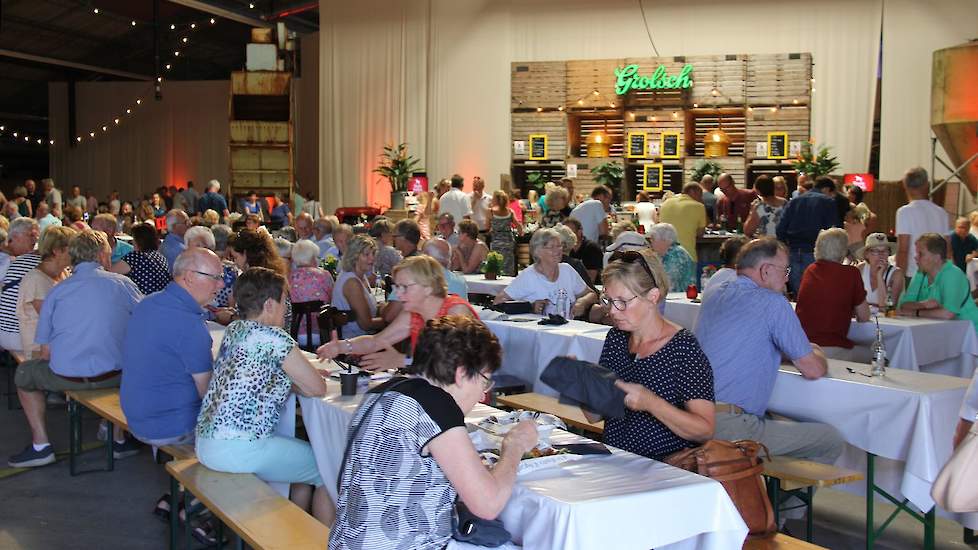 Binnen geen hooibalen, maar lange tafels en banken waar de bezoekers kunnen plaatsnemen. Anderhalf uur voor de aanvang van de voorstelling is de hangar al toegankelijk. Bij de middagvoorstellingen kan het publiek hier lunchen. Bij de avondvoorstellingen i