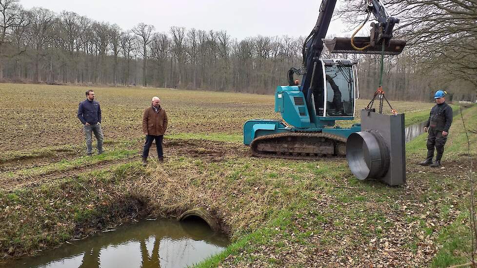 Gebiedsmakelaar Daniël Nieuwenhuis (links), Heemraad Peter Schrijver (midden) en servicemedewerker Gé Brouwer (rechts) bekijken waar de stuw moet komen.