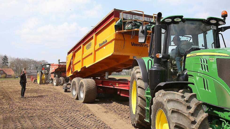 De akkerbouwer verzorgt de toevoer van het pootgoed. Hij rijdt voortdurend heen en weer om de poters vanuit de schuur naar het land te brengen.