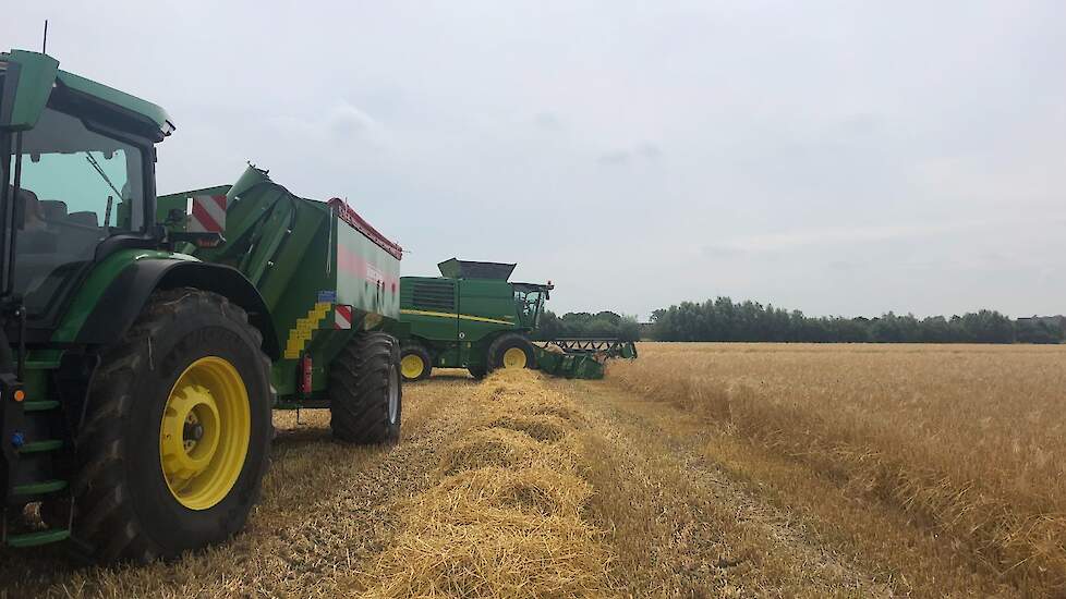 De overslagwagen staat achter een John Deere, ook de combine is van John Deere.