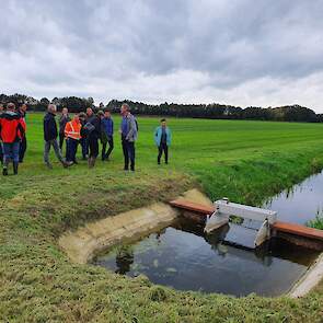 Deelnemende melkveehouders en medewerkers van het waterschap bekijken de nieuw aangelegde stuw.